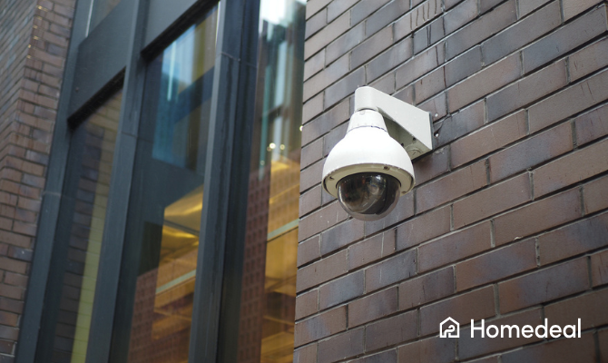 Beveiligingscamera die bevestigd is aan een bakstenen muur van een bedrijfspand