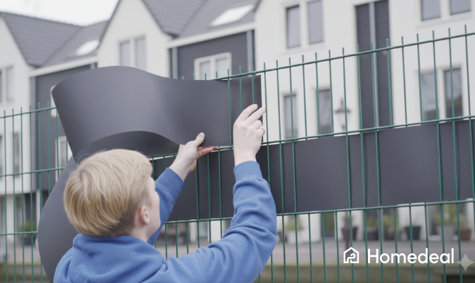 Jonge man vlecht kunststof band door dubbelstaafmathekwerk voor privacy