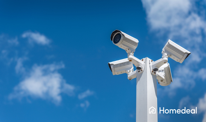 Paal met vier beveiligingscamera's met op de achtergrond een blauwe lucht
