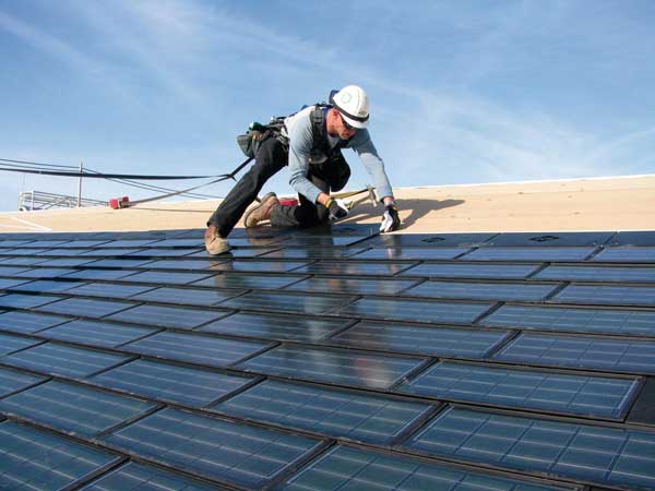 Een vakspecialist plaatst zonnepanelen op een dak.