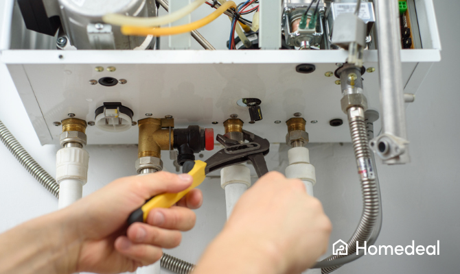 Een man met gereedschap controleert de leidingen die op de CV-ketel passen