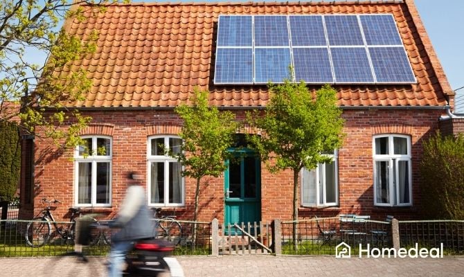 Traditioneel huis met rode dakpannen en blauwe zonnepanelen op het dak.
