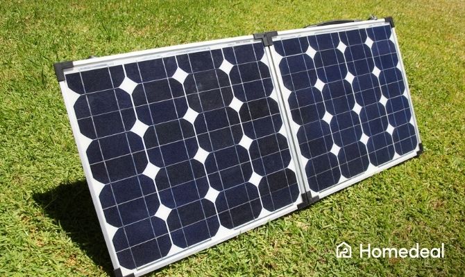 Opgevouwen draagbaar zonnepaneel met twee panelen in de tuin voor het opwekken van zonne-energie.