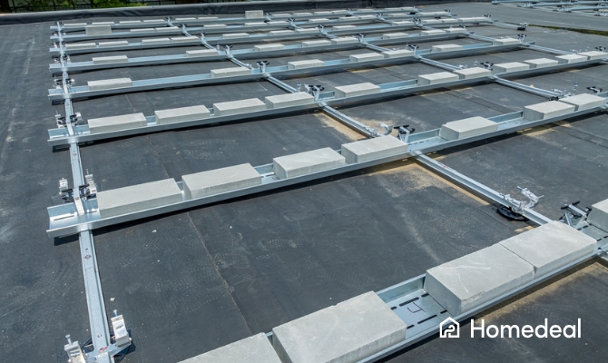 metalen montageframe met betonnen ballastblokken voor de installatie van nieuwe zonnepanelen op een plat EPDM dak.