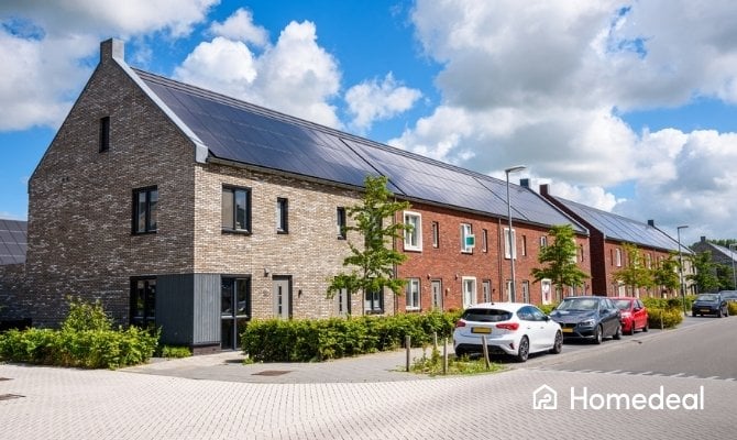 Rij moderne woningen met volledig zwarte zonnepanelen op schuine daken.