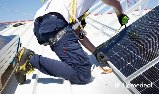 Installateur meet en monteert zonnepaneel op metalen dak tijdens plaatsing