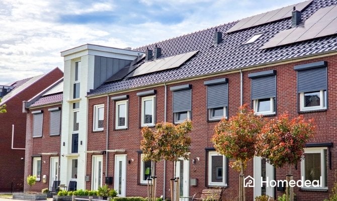 Rij moderne eengezinswoningen met rode bakstenen gevels en zonnepanelen op het dak.