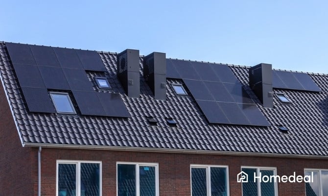 Schuin dak van een modern huis met meerdere zwarte zonnepanelen en dakramen.