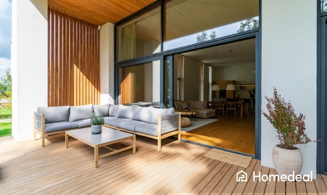 Donkere kunststof maatwerk kozijnen, buitenaanzicht van een moderne woning met terras.