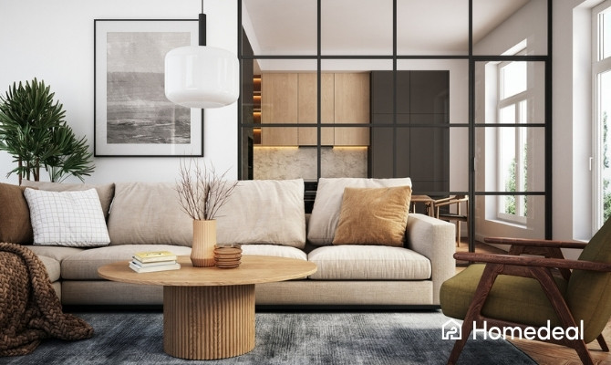 Gezellig ingerichte woonkamer met beige zetel, houten salontafel en zwarte glazen scheidingswand naar de keuken.