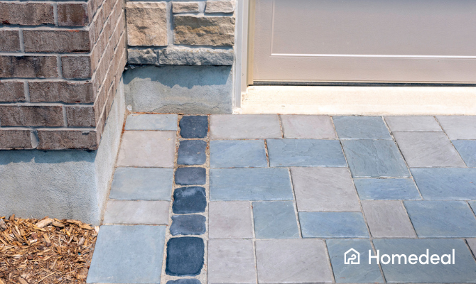 Detail van sierbestrating van een tuin bij de voordeur