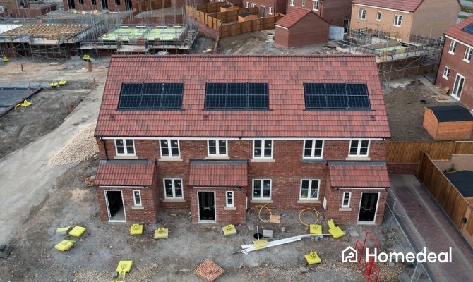 Nieuwbouwwoningen met rood pannendak en geïntegreerde indak zonnepanelen in bouwfase.
