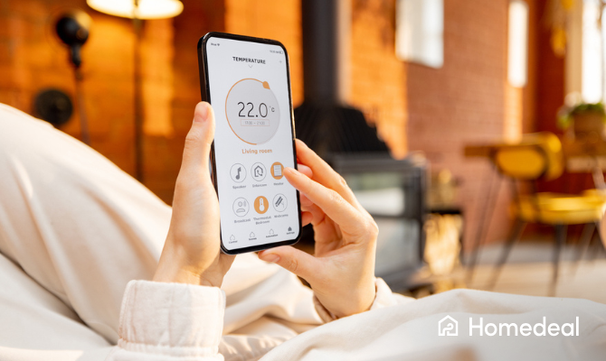 Vrouw ligt op de bank met telefoon en past de temperatuur aan via een app