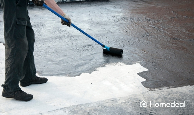 Dakdekker brengt vloeibare dakbedekking aan op een plat dak met een roller. De waterdichte coating zorgt voor bescherming tegen vocht en verlengt de levensduur van de bestaande dakbedekking.