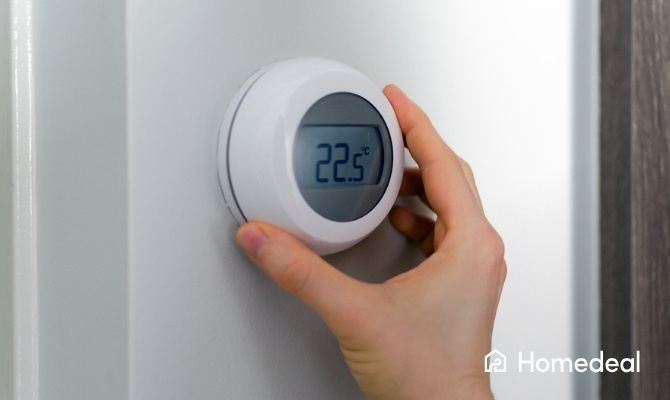 Persoon is doormiddel van draaien aan de knop de thermostaat aan het instellen op 22.5 graden
