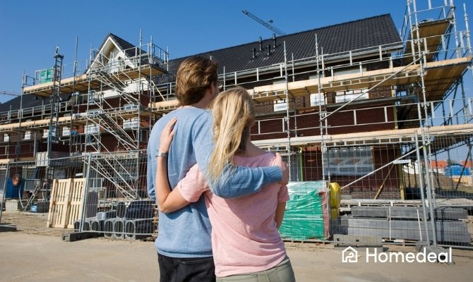 Koppel bekijkt vol verwachting hun nieuwbouwhuis tijdens de bouw.