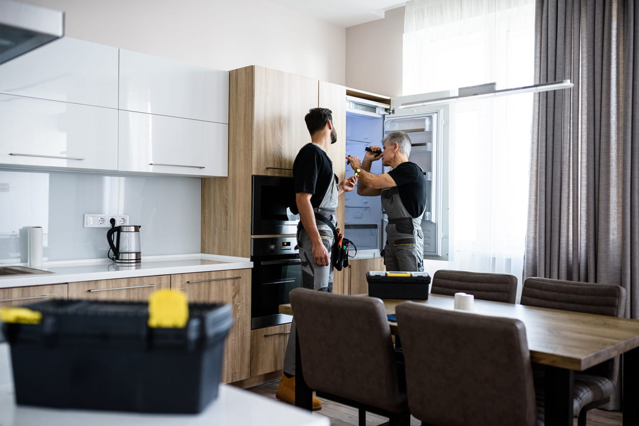 2 Keuken specialisten aan het werk aan de koelkast