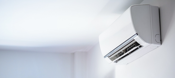 Een split airco bevestigd aan een witte muur op een witte muur
