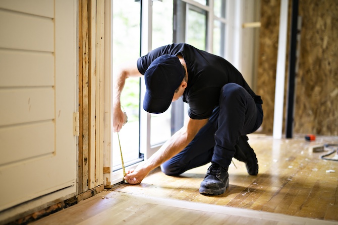 Een vakspecialist is de schuifpui aan het opmeten om de schuifpui te vervangen