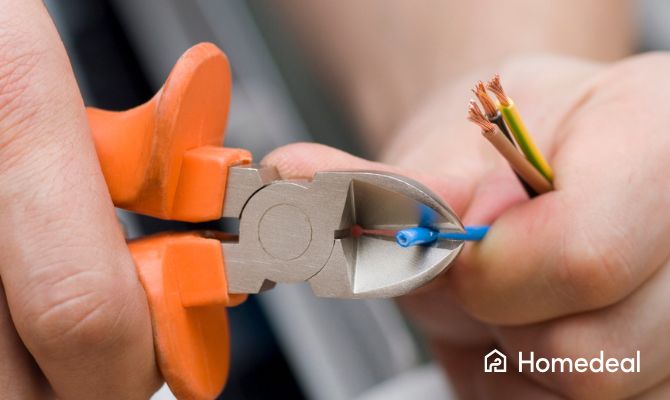 Close up - man knipt elektriciteitsdraden door met een kniptang