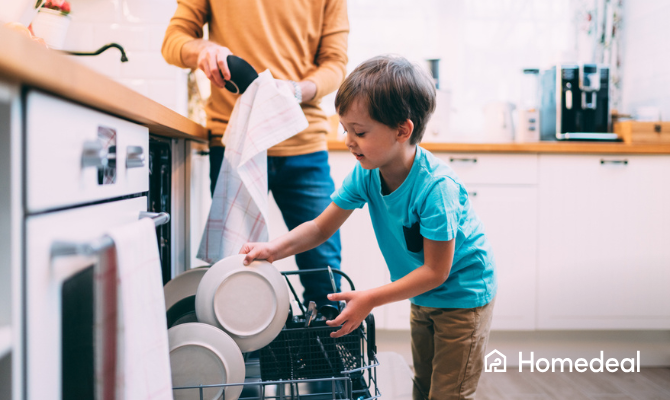 Jonge zoon die vader met de vaatwasser helpt