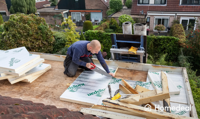 Vakspecialist zaagt en plaatst PIR isolatieplaten om een plat dak te isoleren