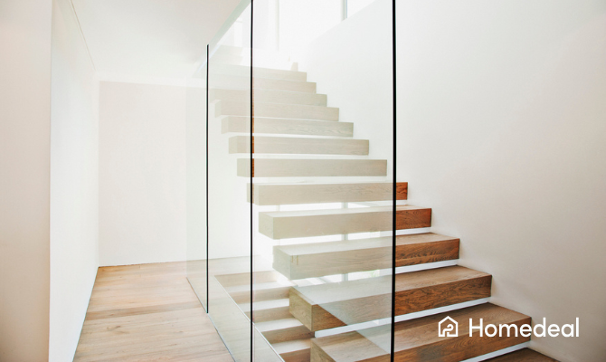 Glazen wand naast een open trap in een modern huis
