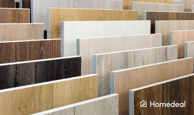 Showroom met verschillende soorten vloeren, waaronder houtlook tegels, pvc vloeren en laminaat in diverse kleuren en structuren.